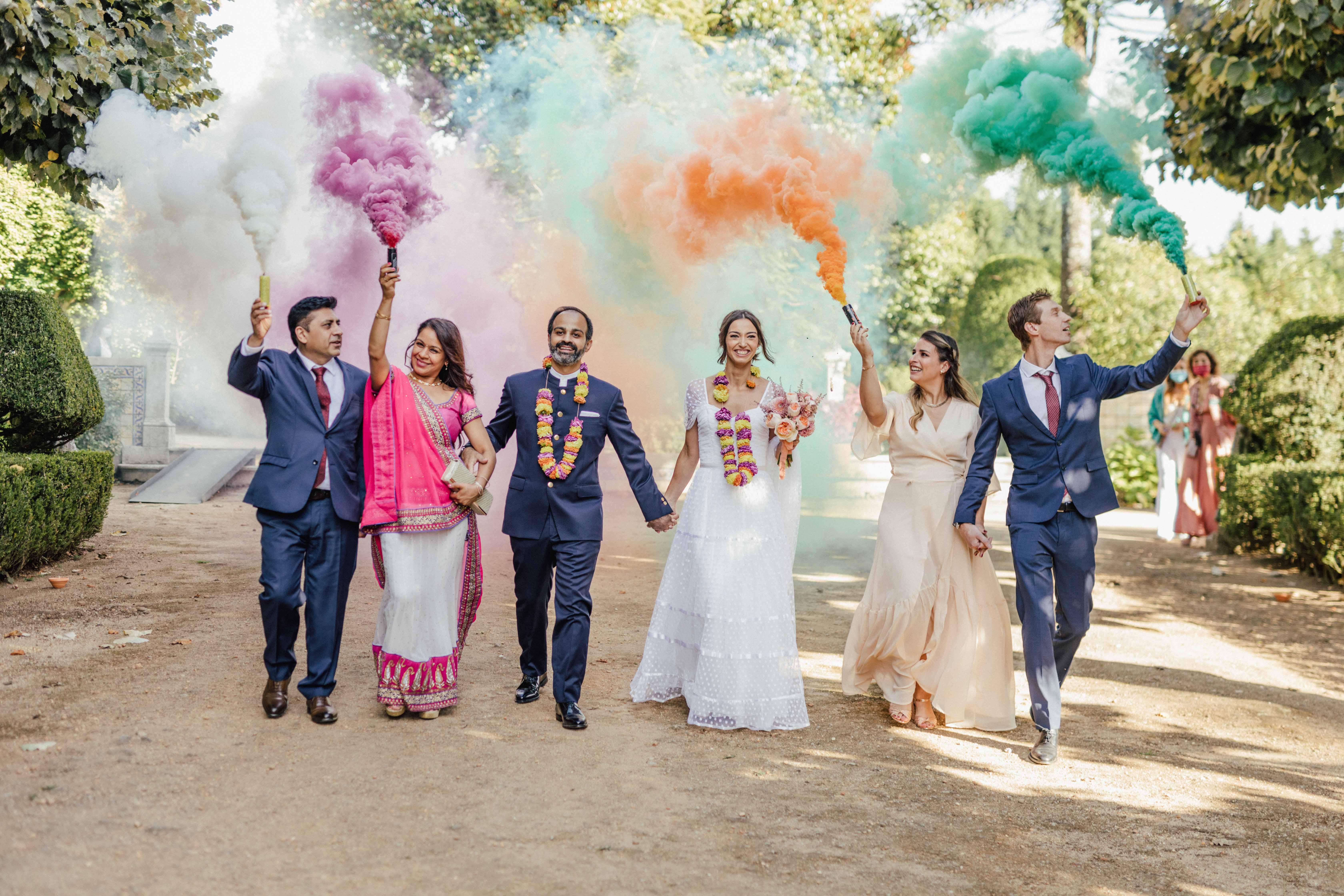 Saída do casal com fumos coloridos verde, laranja e rosa, acompanhados pelas famílias dos dois lados