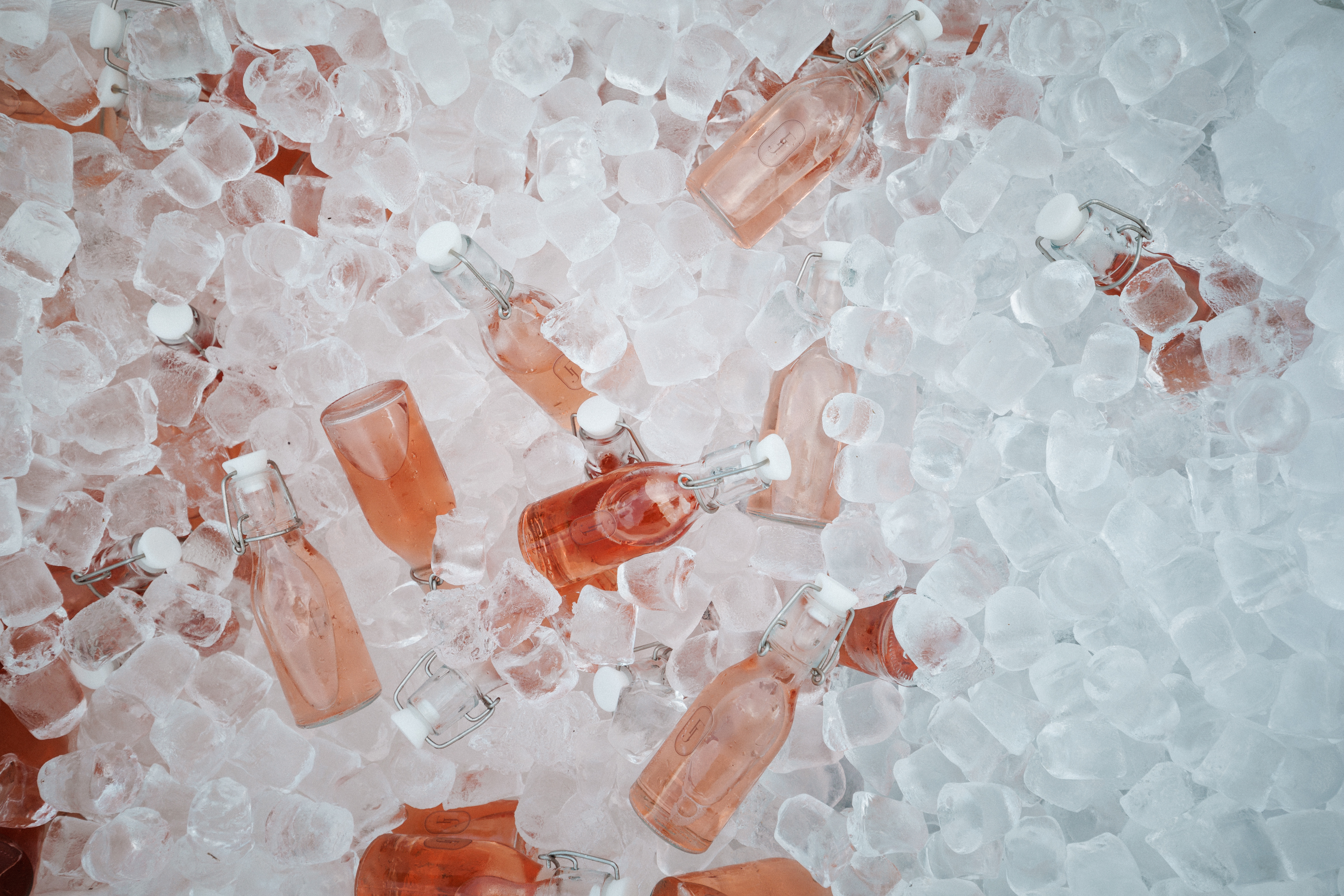 Flat lay of pink bottles in ice, a brand activation moment.