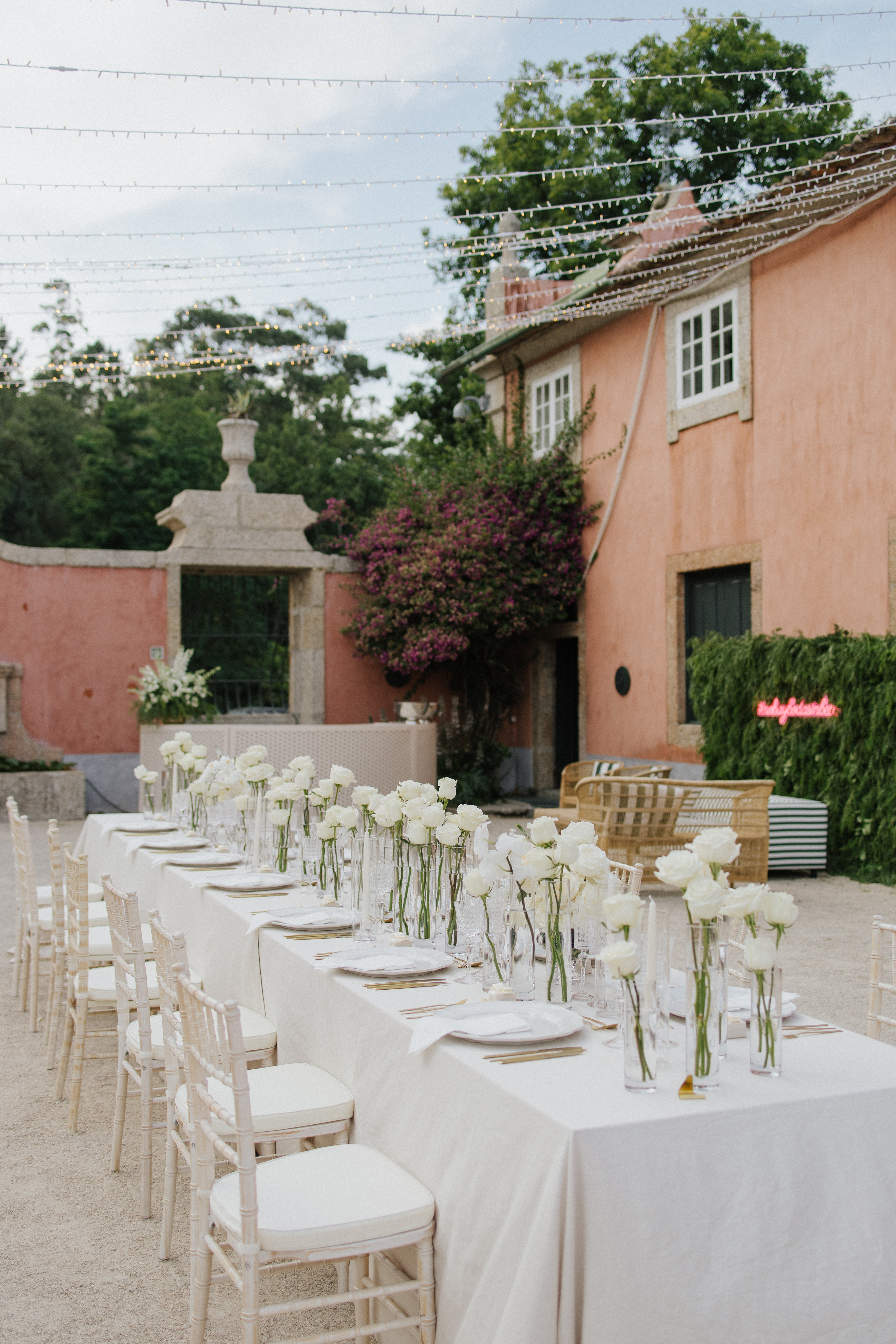Pátio de Casa de Sezim ao entardecer, com mesas longas e fairy lights
