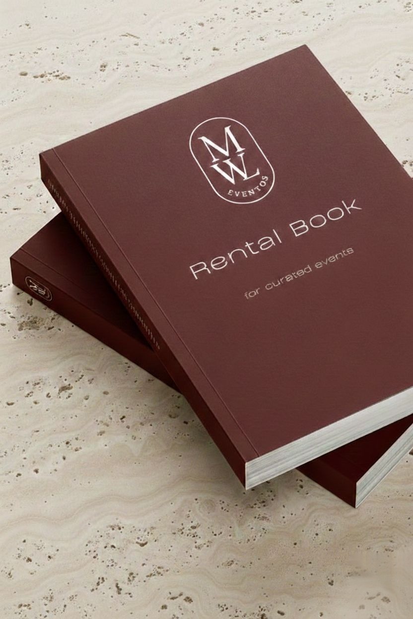O Rental Book da Made With Love, em borgonha com o monograma MWL Eventos, fotografado como objecto físico